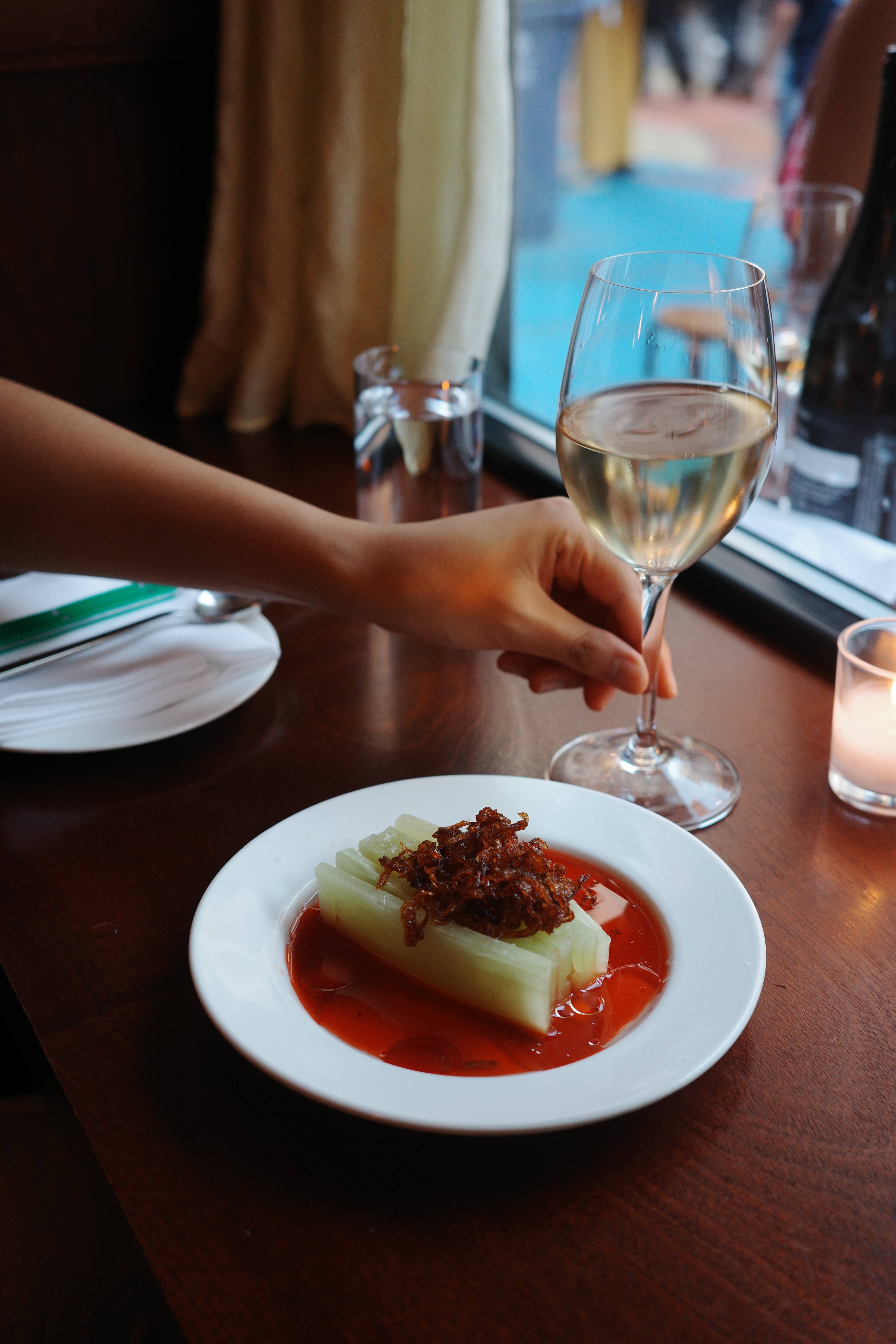 Left: Counter seating. Right: Chilled celtuce and a glass of wine.